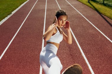 Dövüş teknikleri çalışıyorum. Spor elbiseli genç bayan dışarıda egzersiz yapıyor..