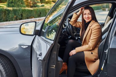 Kadın modern siyah otomobilde oturuyor..