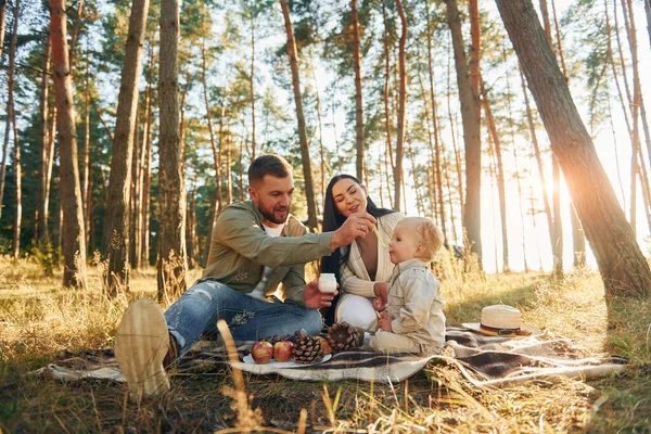 食べ物を食べる 父と母と娘の幸せな家族が森の中にいる — ストック写真