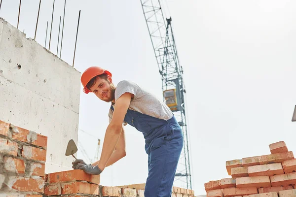 Sostiene Ladrillos Joven Trabajador Construcción Uniforme Está Ocupado Edificio Sin — Foto de Stock