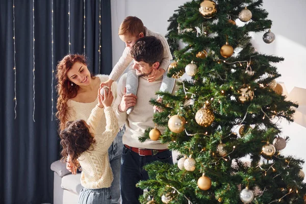 Noel ağacı süslemek. Yeni yılı evde çocuklarıyla kutlayan aileler..