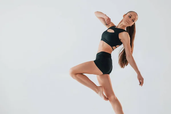 Студії Білому Тлі Молода Жінка Спортивному Одязі Займається Гімнастикою Приміщенні — стокове фото