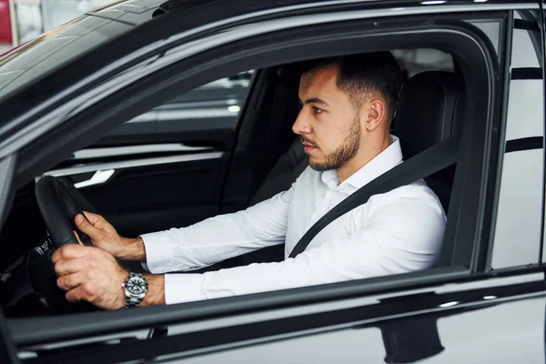 Menestyvä Mies Nuori Kaveri Valkoisessa Paidassa Istuu Modernin Uuden Auton — kuvapankkivalokuva