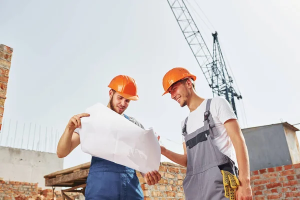 Leseplan Zwei Junge Bauarbeiter Uniform Sind Rohbau Beschäftigt — Stockfoto