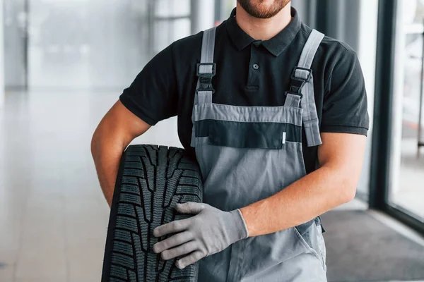 Sostiene Neumático Hombre Uniforme Trabaja Autosalón Durante Día — Foto de Stock