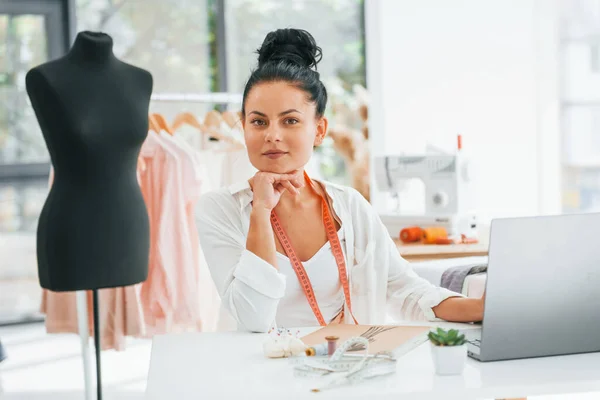 노트북을 이용해서 일하고 있습니다 Seamstress 그녀의 사무실에 있습니다 — 스톡 사진