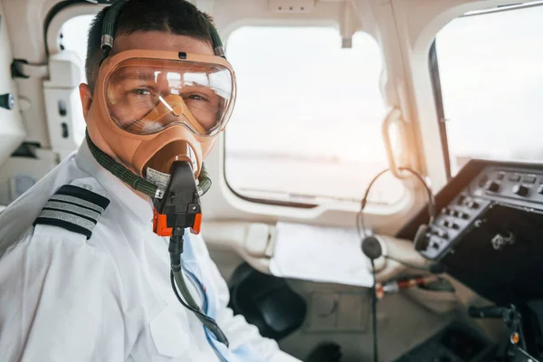 In oxygen mask. Pilot on the work in the passenger airplane. Preparing for takeoff.