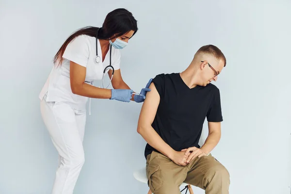 男人很紧张穿制服为病人注射疫苗的医生 — 图库照片