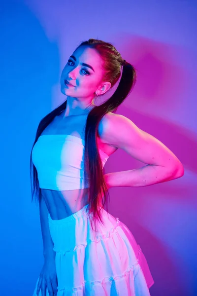 Etekli Stüdyoda Neon Işığıyla Duran Şık Bir Genç Kadın — Stok fotoğraf