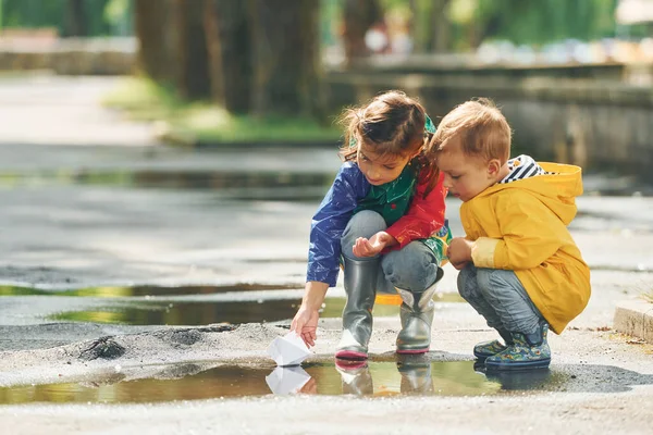 Birikintisinde Çocuklar Yağmurdan Sonra Parkta Eğleniyorlar — Stok fotoğraf