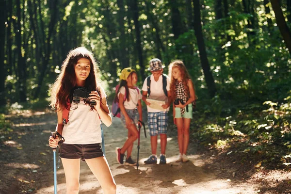Dziewczyna Stojąca Przed Przyjaciółmi Dzieci Spacerujące Lesie Sprzętem Podróżniczym — Zdjęcie stockowe