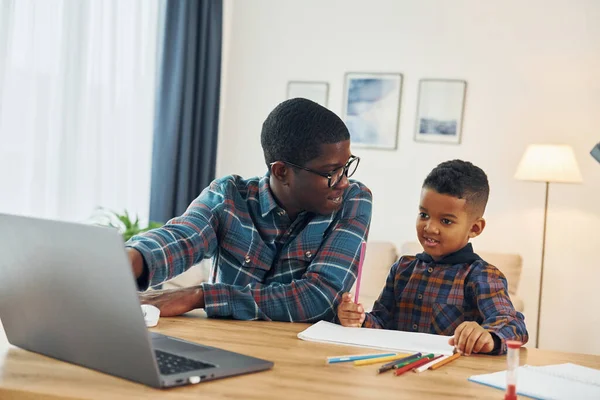 Birlikte çiziyoruz. Afrikalı Amerikalı baba ve küçük oğlu evde..