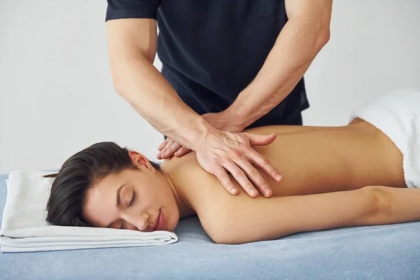 Jovem Mulher Está Deitada Quando Homem Fazendo Massagem Suas Costas — Fotografia de Stock
