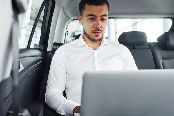 Funziona Utilizzando Computer Portatile Giovane Uomo Camicia Bianca Seduto All — Foto Stock