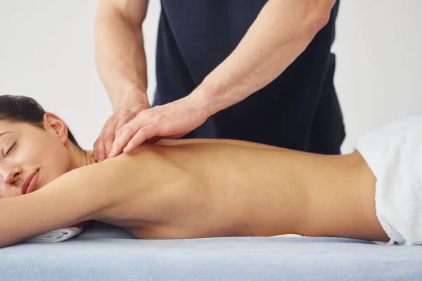 Jovem Mulher Está Deitada Quando Homem Fazendo Massagem Seu Corpo — Fotografia de Stock