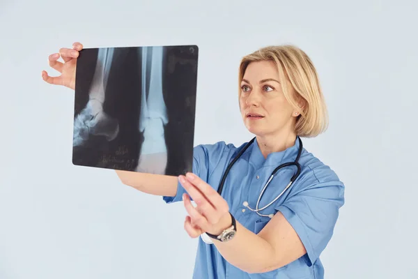 Röntgen Tutuyor Üniformalı Steteskoplu Orta Yaşlı Profesyonel Kadın Doktor — Stok fotoğraf