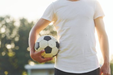 Durup poz vermek. Genç futbolcu spor sahasında antrenman yapıyor..