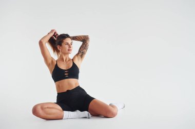 Yerde oturuyordu. Stüdyoda seksi vücutlu, baştan çıkarıcı, güzel bir kadın poz veriyor..