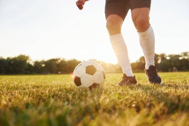 Manzarayı kapat. Genç futbolcu spor sahasında antrenman yapıyor..