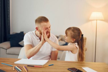 Masada oturup eğlenmek. Baba ve küçük kızı evde birlikteler..