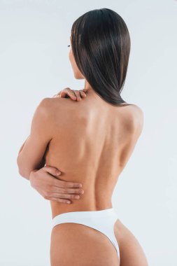 Dikiz aynası. Stüdyoda iç çamaşırlı, zayıf vücutlu bir kadın var..