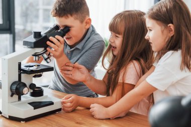 Mikroskopla. Çocuklar gündüz vakti evlerinde eğleniyorlar..