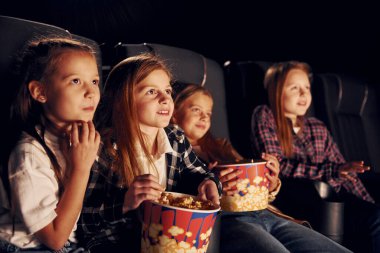 Rahatlıyorum ve eğleniyorum. Bir grup çocuk sinemada oturup birlikte film izliyorlar..