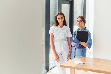 İçeride dikilen ve birlikte çalışan üniformalı iki doktor..