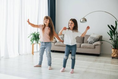 Birlikte dans etmek. Çocuklar gündüz vakti evlerinde eğleniyorlar..