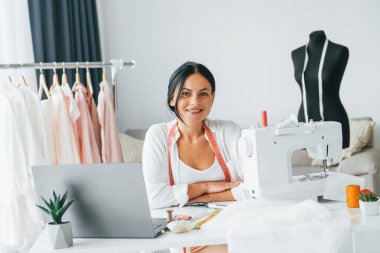 Profesyonel dikiş makinesi. Terzi odasında, farklı kıyafetlerle..