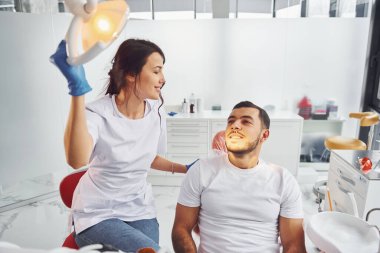 Ağız muayenesi. Klinikte dişçiye giden bir adam. Stomatoloji kavramı.