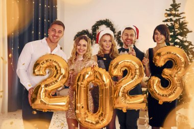 2023 geliyor. Bir grup insan içeride yeni yıl partisi veriyor..