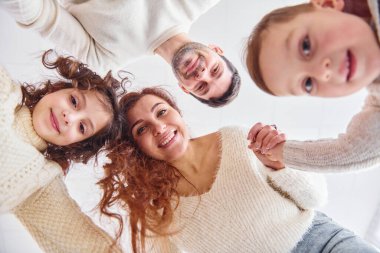 Gülümsüyor ve eğleniyor. Aşağıdan bak. Mutlu aile aşağı bakıyor.
