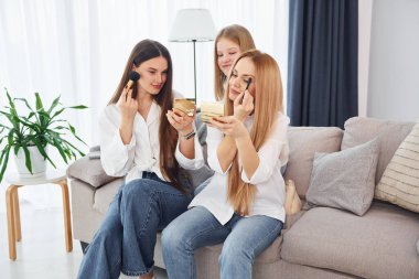 Hafta sonu aktiviteleri. Genç anne ve iki kızı gündüz vakti evdeler..