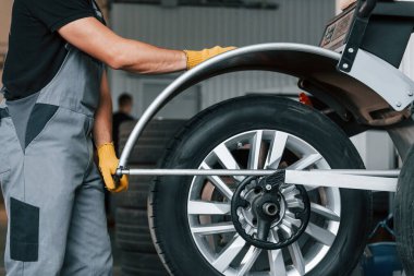 Lastiği tamir ediyorum. Üniformalı adam otomobil servisinde çalışıyor..