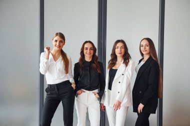 Resmi giysiler içinde ofiste birlikte olan bir grup yetişkin kadın..