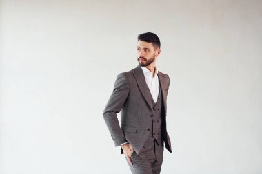 Beyaz arka planda kamera için poz vermek. Takım elbiseli genç bir işadamı..