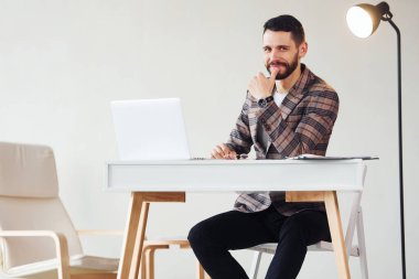 Laptop kullanıyor. Takım elbiseli genç bir iş adamı. Başarı kavramı.