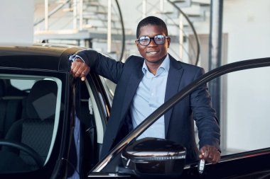 Anahtarları elinde tutuyor. Siyah takım elbiseli genç Afro-Amerikan iş adamı Ototalon..