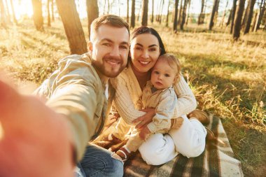 Selfie çekiyorum. Mutlu baba, anne ve kız çocukları ormanda..
