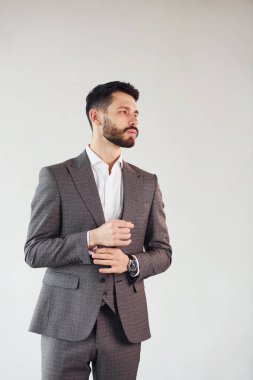 Beyaz arka planda kamera için poz vermek. Takım elbiseli genç bir işadamı..