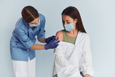 Basit ama etkili bir işlem. Üniformalı doktor hastaya aşı yapıyor..
