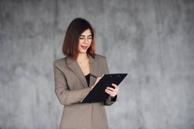 Not defteri tutuyor. Resmi giysili genç bayan içeride. Tarz kavramı.