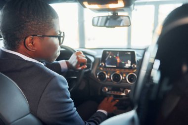 Dikiz aynası. Siyah takım elbiseli genç Afro-Amerikan işadamı otomobilde..