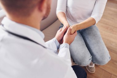 Müşteriyi ellerinden tutmak. Klinikte beyaz önlüklü profesyonel doktor var..