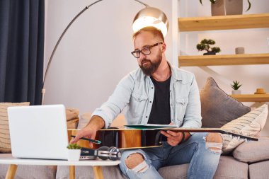 Yaratıcılık kavramı. Gündelik giysiler içinde ve akustik gitarlı bir adam içeride..