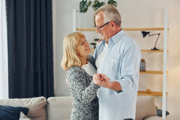 Dancing in the domestic room. Senior man and woman is together at home.