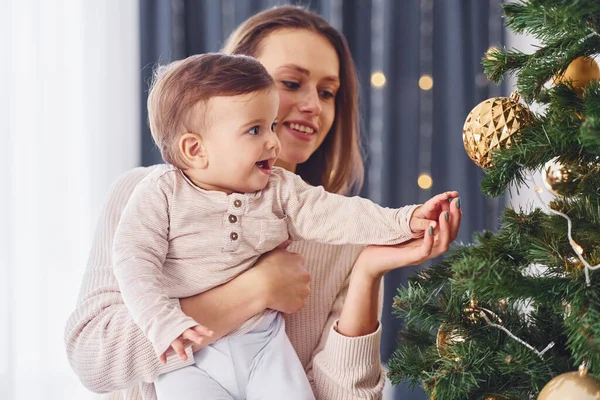 クリスマスツリーを飾る 母親と娘は屋内で一緒に家にいる — ストック写真