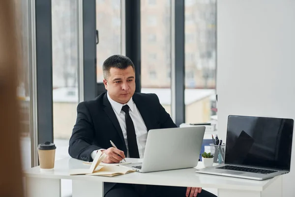 Muž Obleku Kravatě Sedí Vedle Stolu Laptopem Pracuje Kanceláři — Stock fotografie