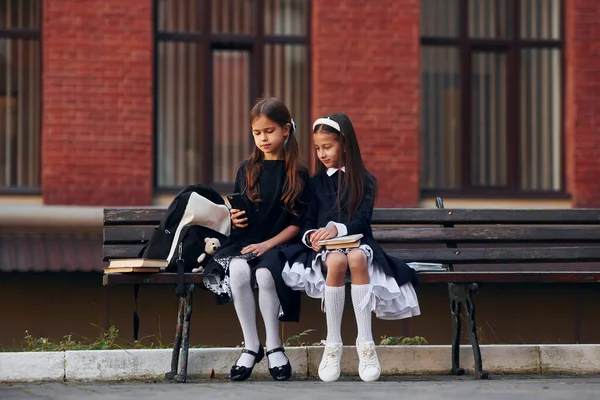 Dos Colegialas Están Sentadas Afuera Juntas Cerca Del Edificio Escolar — Foto de Stock